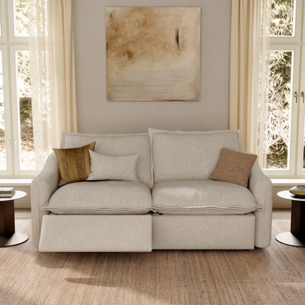 Cream power reclining loveseat with one footrest extended in a bright modern living room