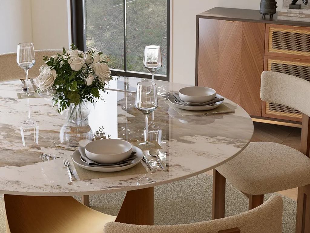 White rose centerpiece on a marble dining table with neutral place settings, upholstered chairs, and a wood sideboard.