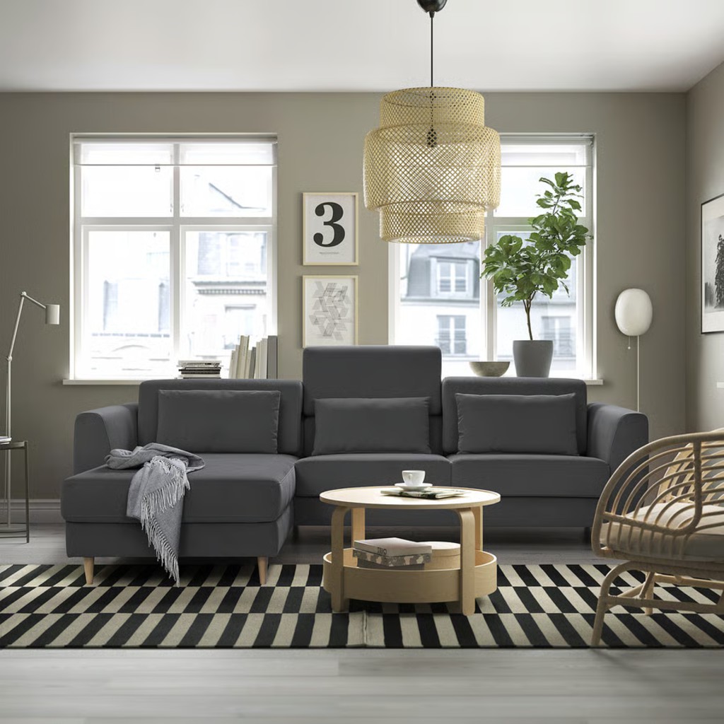 Dark gray sectional sofa with chaise and adjustable headrest in a modern living room