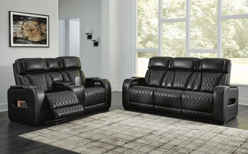 Black leather power reclining sofa and loveseat with diamond stitching in a bright modern living room