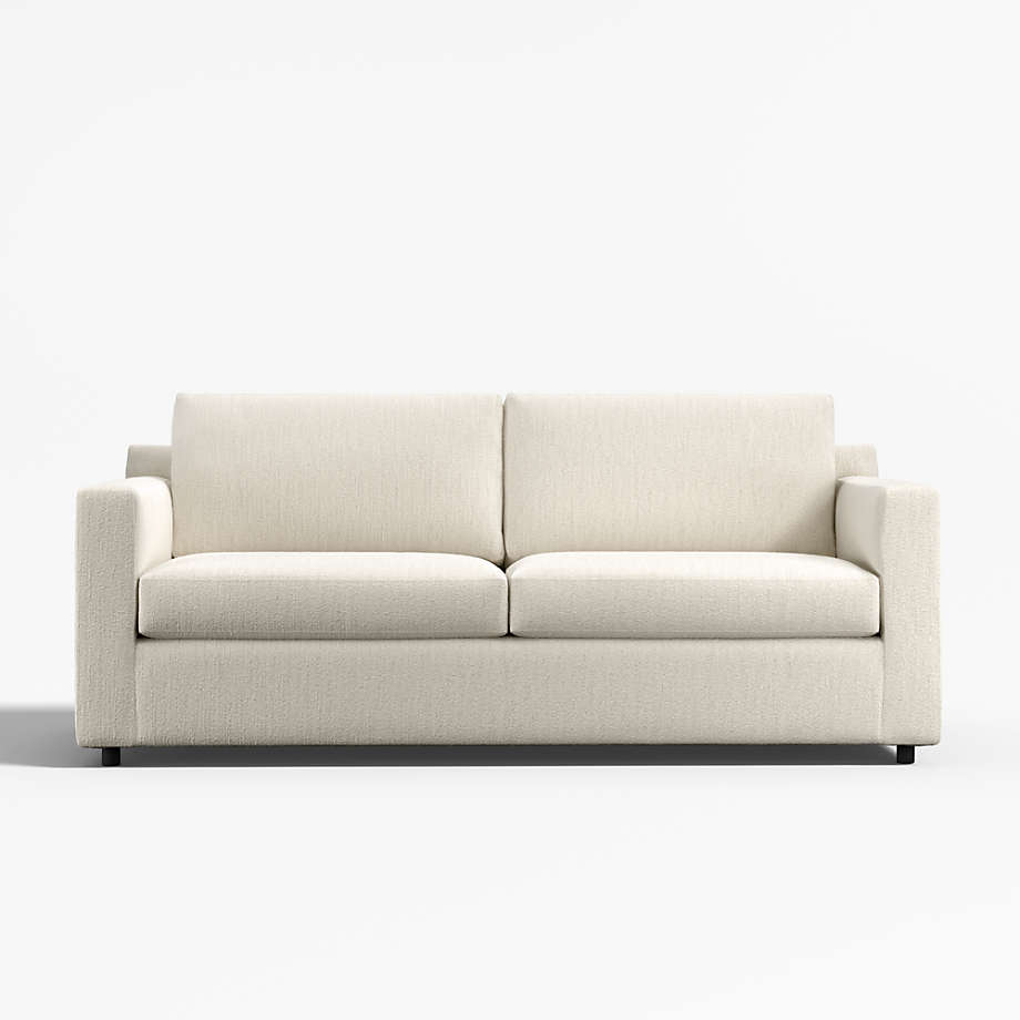 Cream compact sleeper sofa with loose back cushions on a white background.