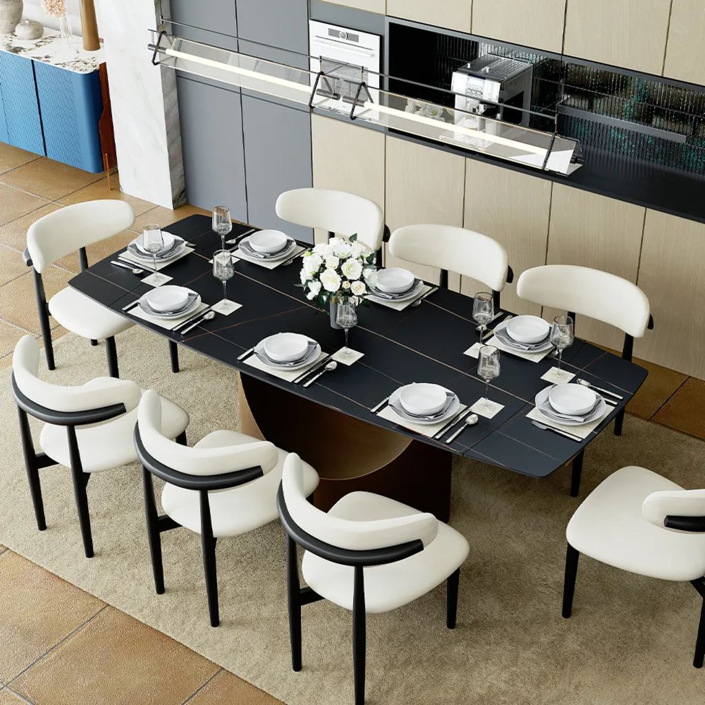 Large black rectangular dining table set for eight with white upholstered chairs in a modern kitchen.