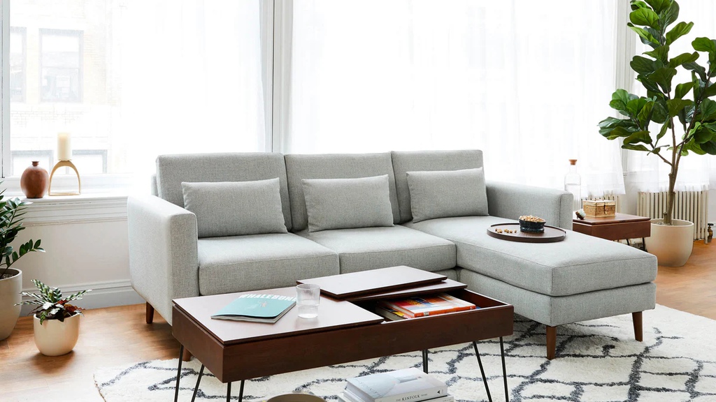 Light gray sectional sofa with chaise and storage coffee table in a bright modern living room