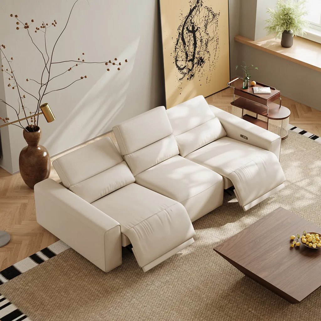 White leather power reclining sofa with extended footrests and adjustable headrests in a modern living room.