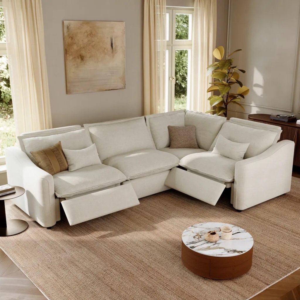 White L-shaped power reclining sectional sofa with three footrests extended in a bright living room.