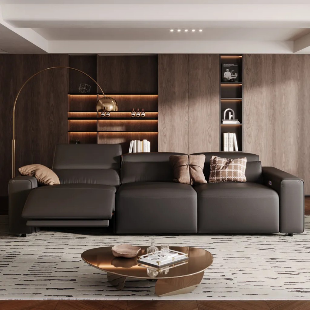 Black leather reclining sofa with an extended footrest in a modern living room with wood-paneled walls.