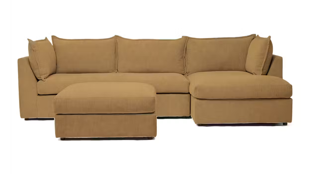 Camel brown sleeper sectional with a movable ottoman, loose back cushions, and low-profile base on a white background.