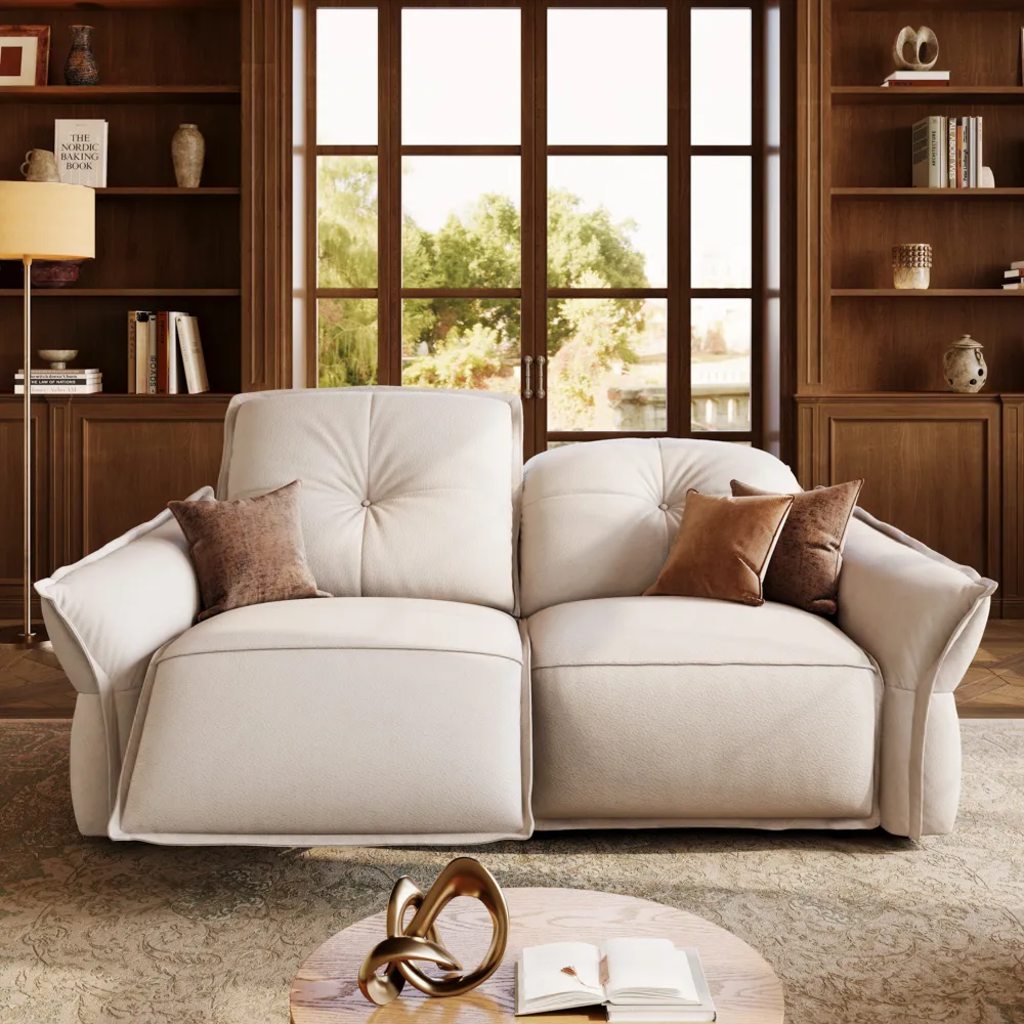 White loveseat with brown accent pillows in a warm wood-paneled living room with built-in bookshelves and large windows.