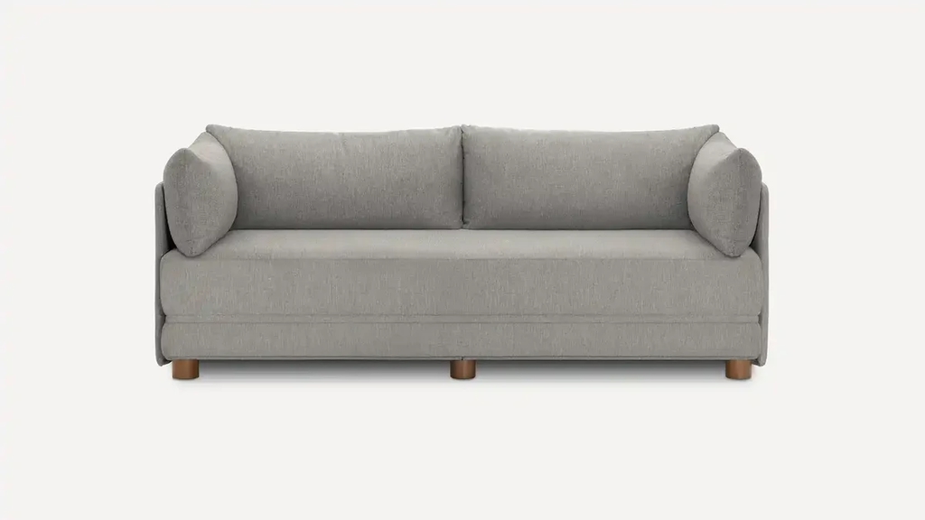 Gray compact sleeper sofa with bolster cushions and wooden legs on a white background