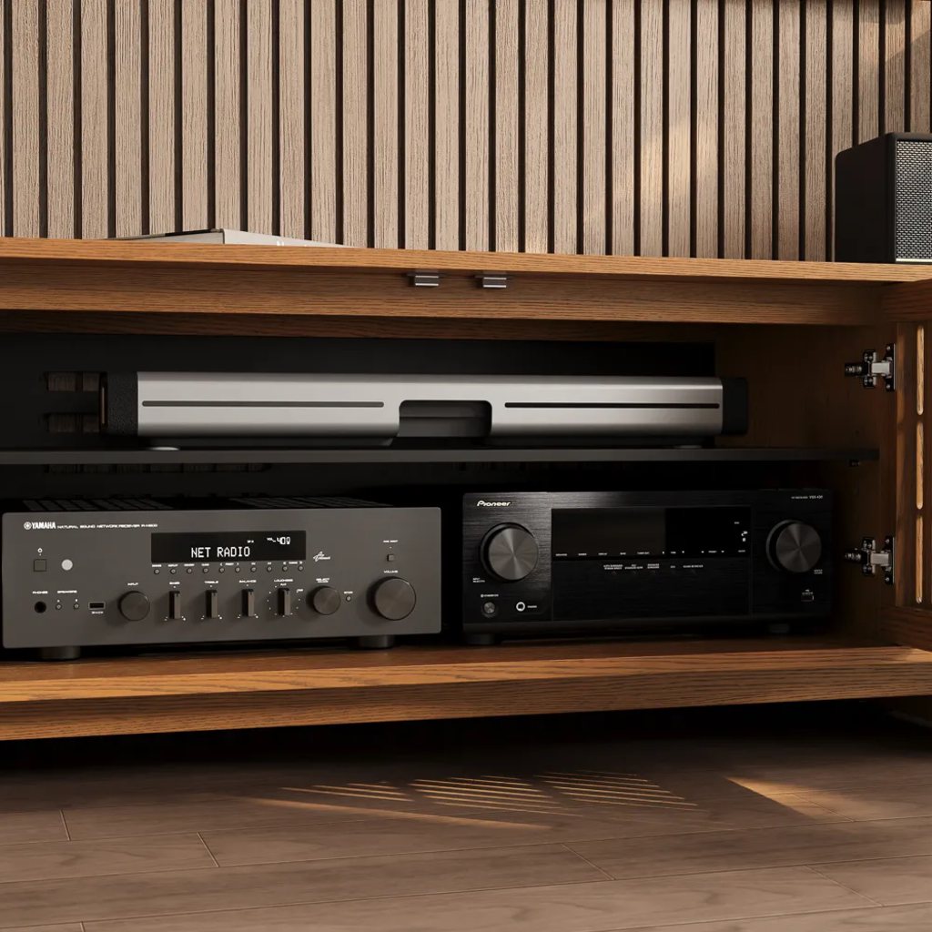 Open walnut media console with adjustable shelving holding a game console, AV receiver, and stereo amplifier.