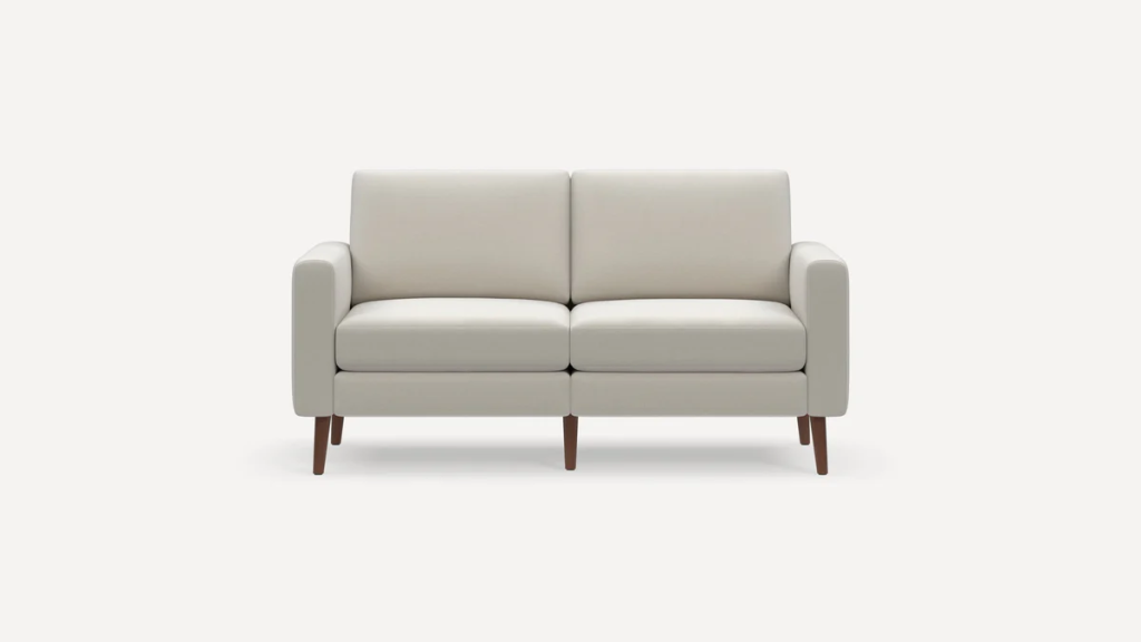 Compact ivory loveseat with slim arms, two seat cushions, and tapered wooden legs on a neutral background.