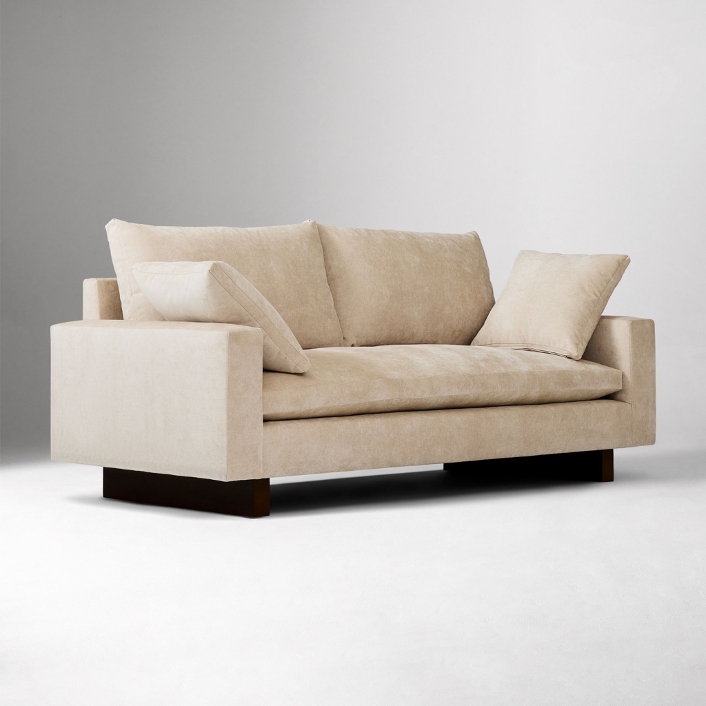 Beige high-seat sofa with square arms and loose cushions against a neutral studio background.