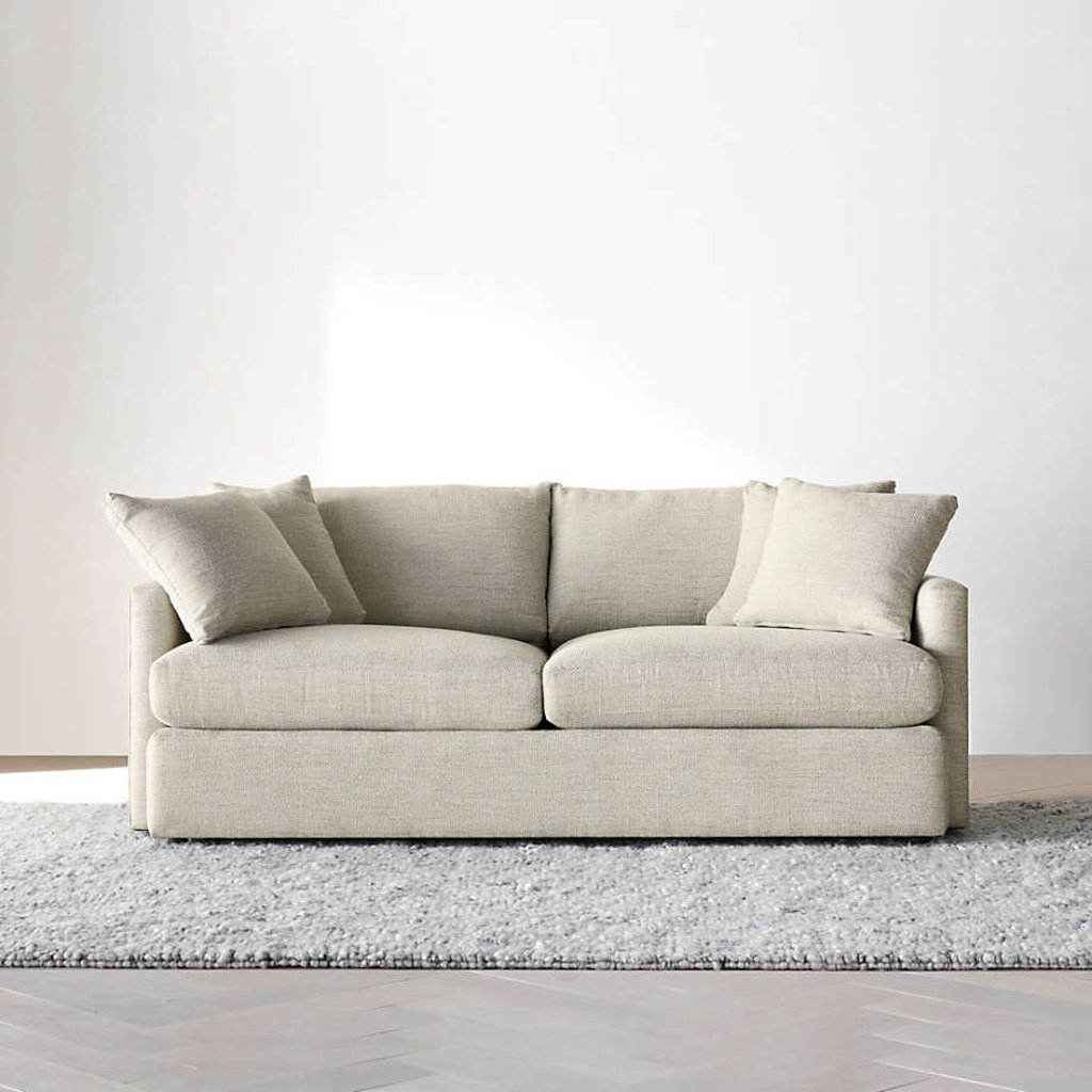 Light beige two-seat sofa with loose cushions in a minimalist living room