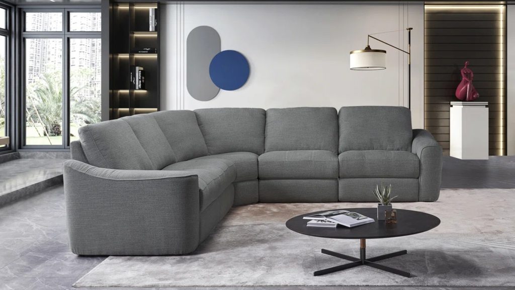 Gray L-shaped sectional sofa with wide cushioned seats in a modern living room.