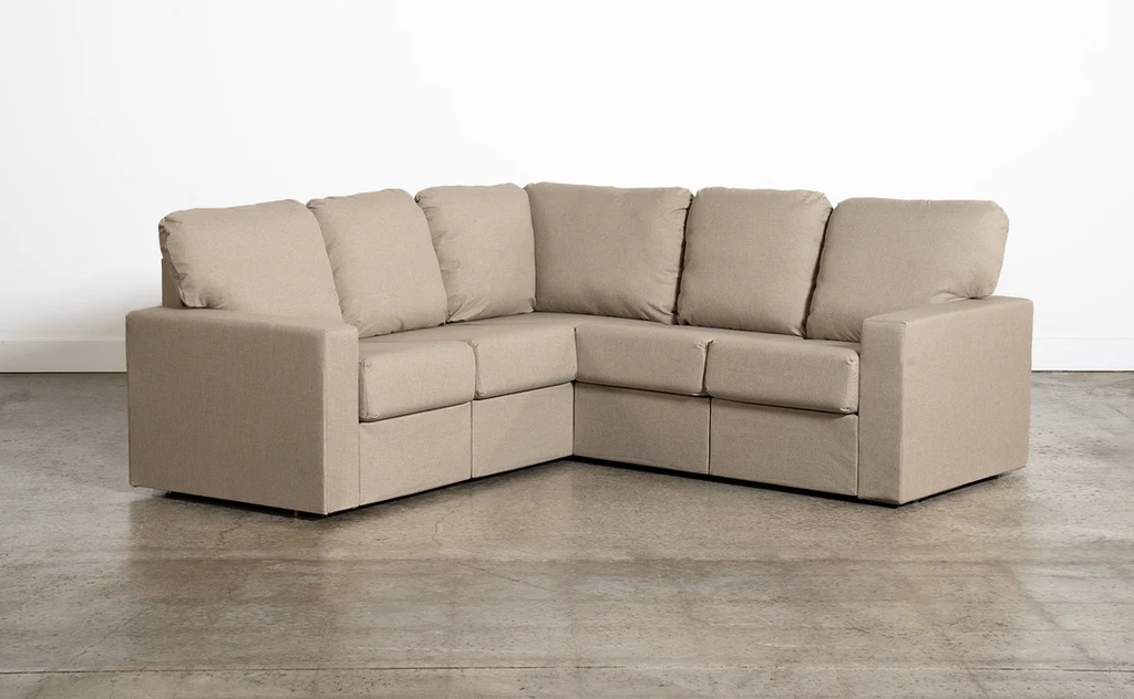 Beige L-shaped sectional sofa with plush back cushions on a neutral studio background.