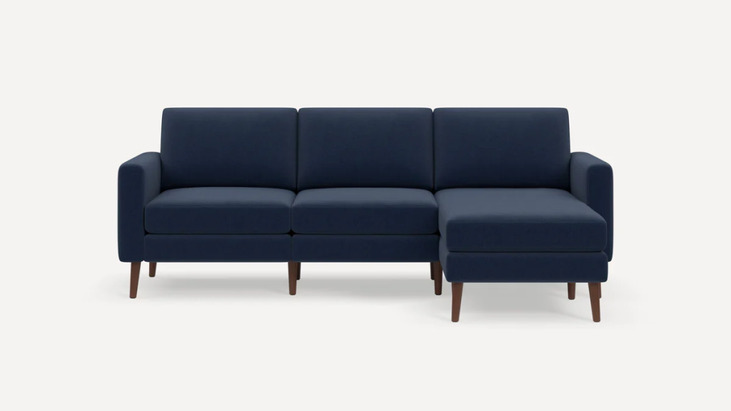 Navy blue modular sofa with a movable chaise ottoman on a white background.