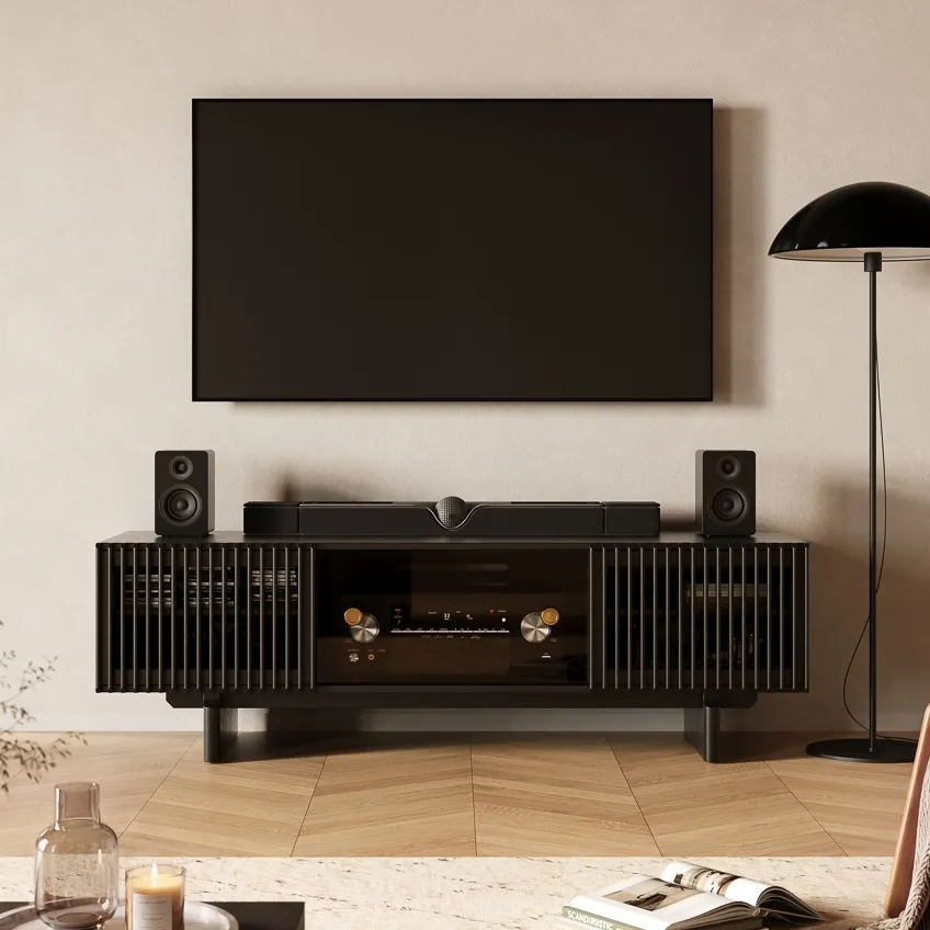 Black media console beneath a wall-mounted TV in a warm living room.