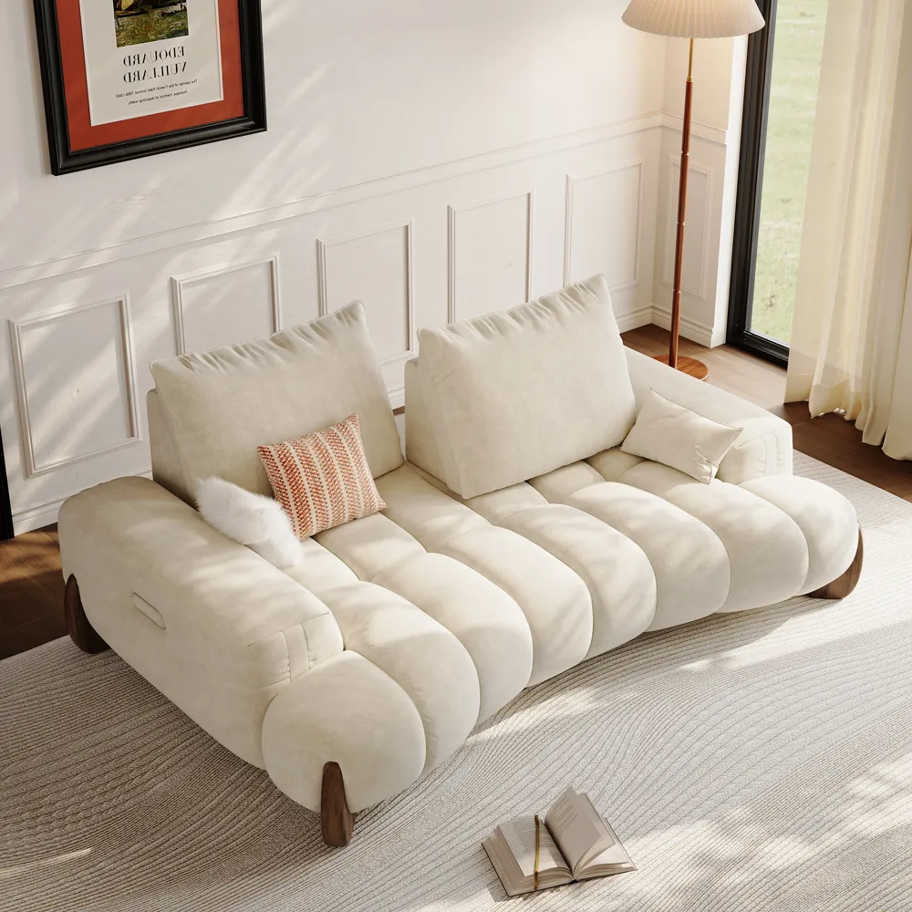 Cream-colored deep-seat sofa with oversized back cushions in a bright living room.