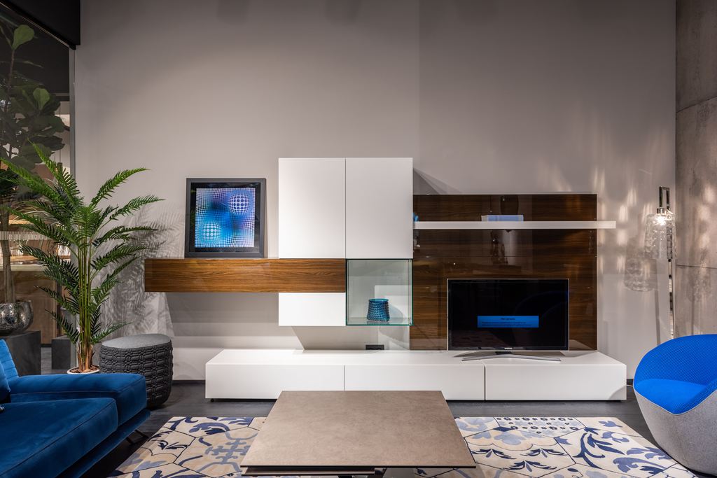 Modern living room with a low-profile white TV stand, wall-mounted storage, and a television.
