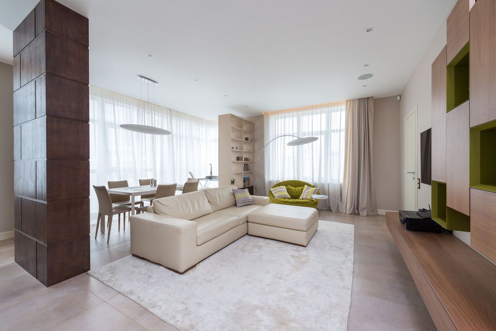White L-shaped sectional sofa with a chaise in a spacious open-plan apartment living room.