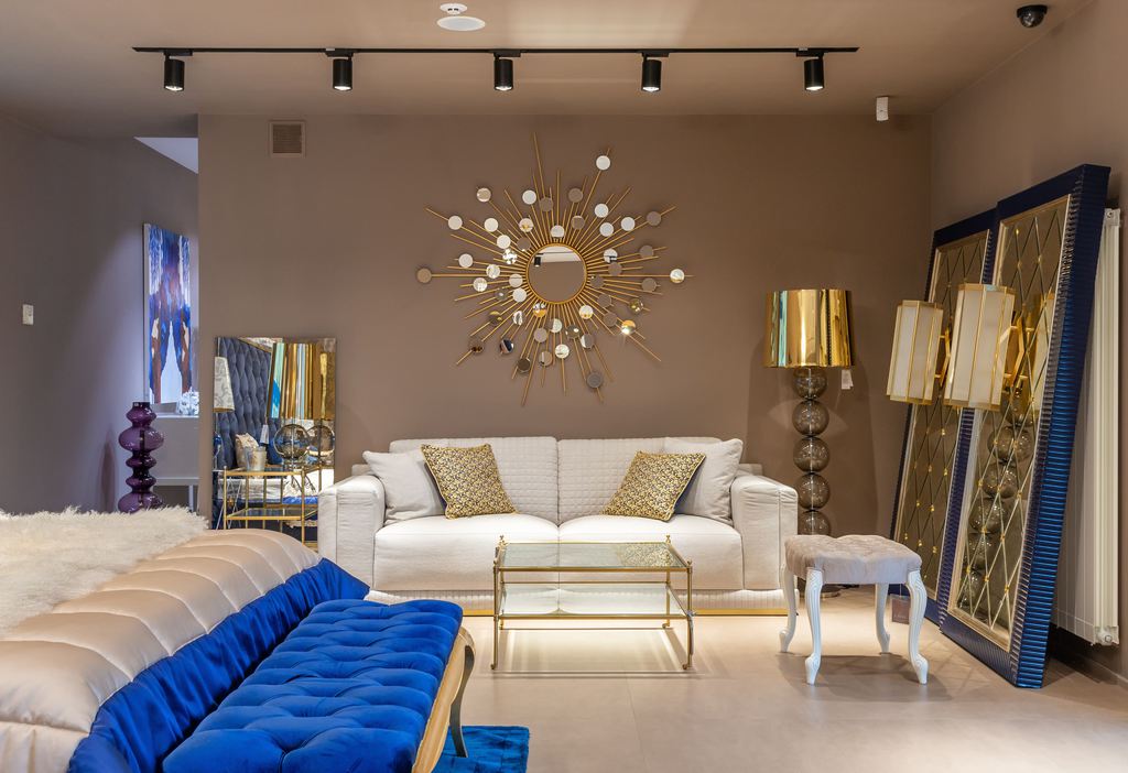 White sofa in a compact showroom-style living room with gold accents and mirrored decor