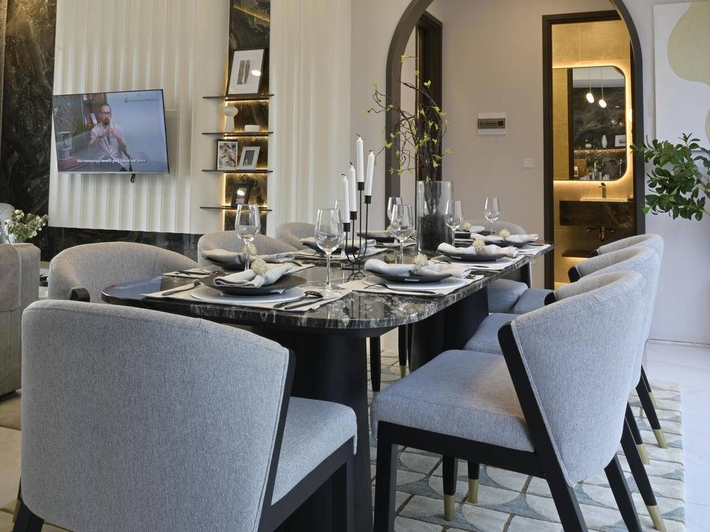 Black stone dining table with gray upholstered chairs beneath crystal pendant lights in a modern dining room.
