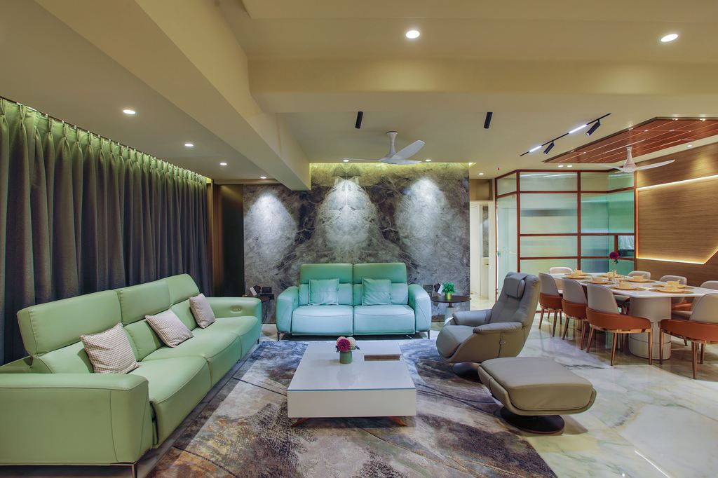 Large open-plan living area with a mint green sofa set, reclining chair and ottoman, coffee table, and connected dining space.