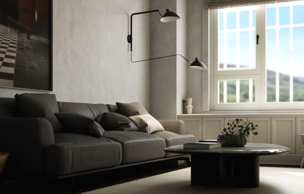 Dark leather sofa beside a round coffee table in a bright modern living room with a large window.