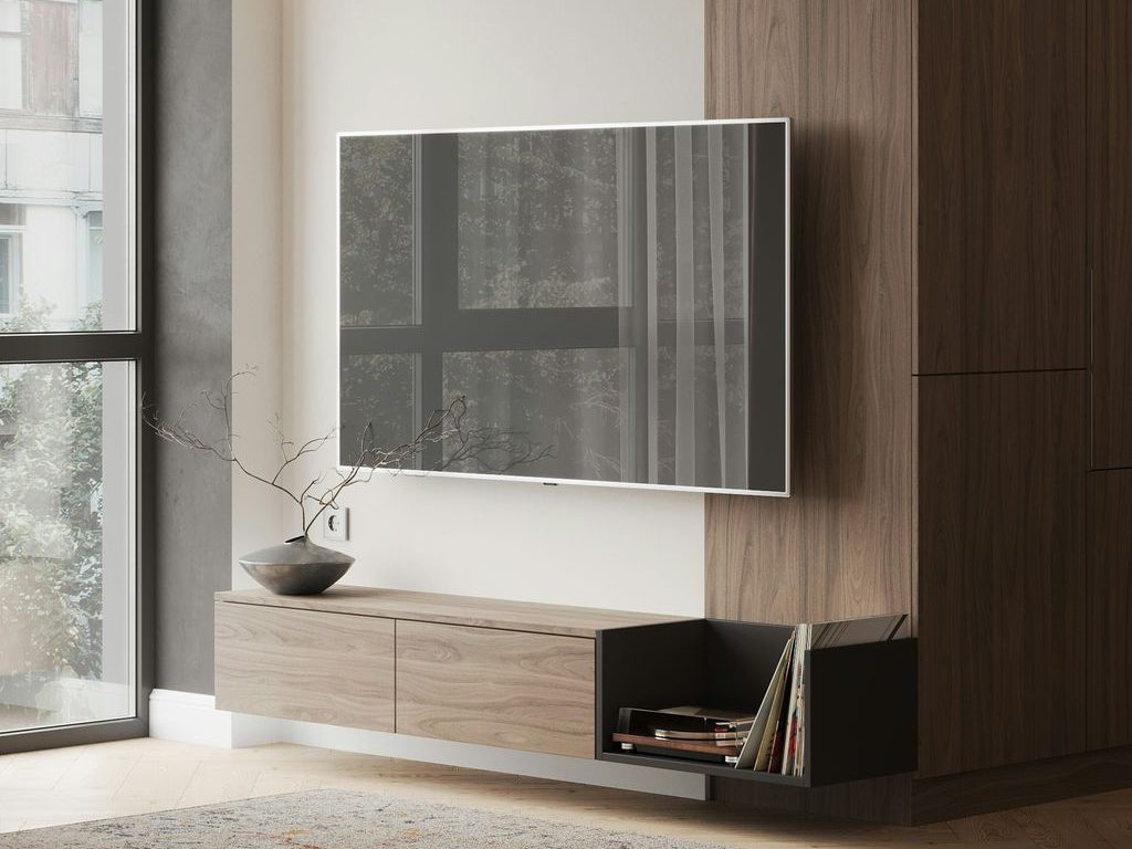 Wall-mounted TV above a floating wood TV stand with closed cabinets and an open record storage shelf.