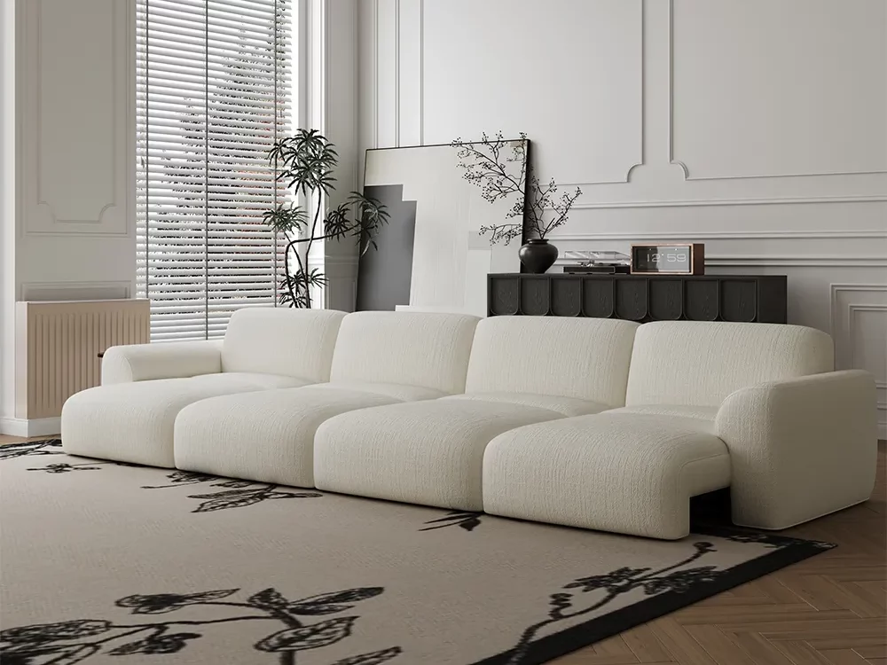 A cream modular sofa in a calm, modern living room with soft light, wood flooring, and a patterned rug. Its open layout highlights the importance of measuring furniture size, clearance, and visual balance before buying.