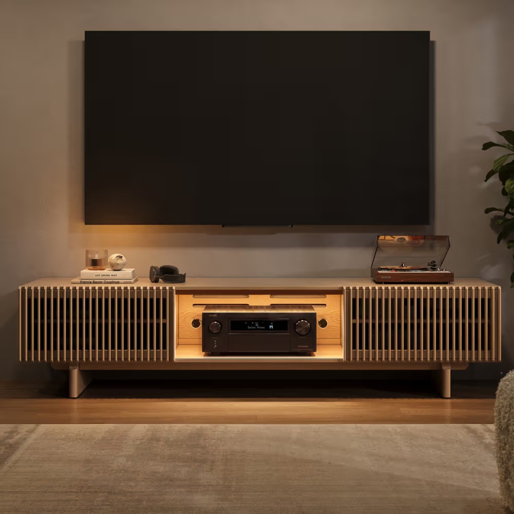 Modern living room with a wall-mounted TV, wooden media console, turntable, AV receiver, and warm ambient lighting.