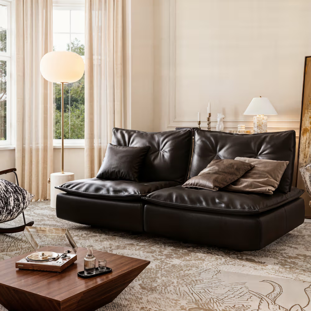 Black leather adjustable-back sofa with plush cushions in a bright, elegant living room.