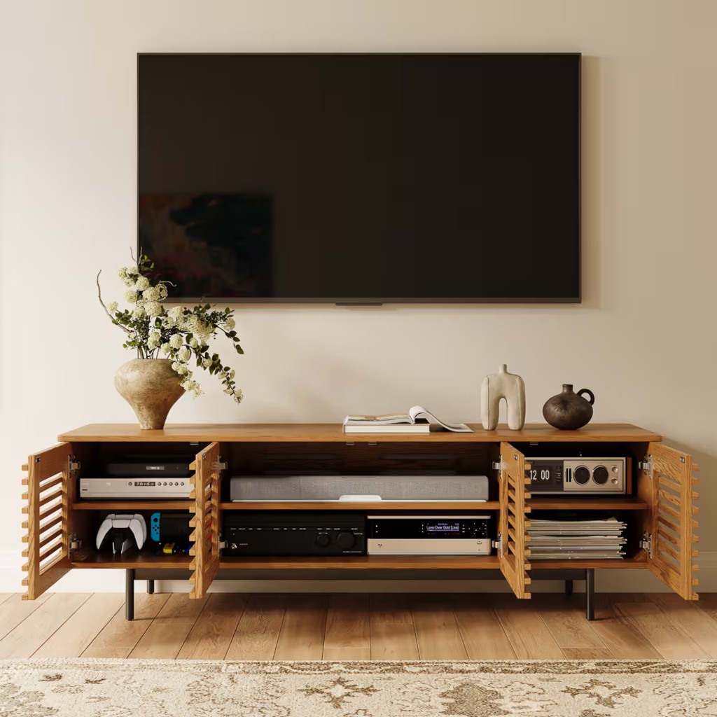 Dark wood TV stand with closed cabinet doors and an open center shelf beneath a wall-mounted TV in a modern living room.