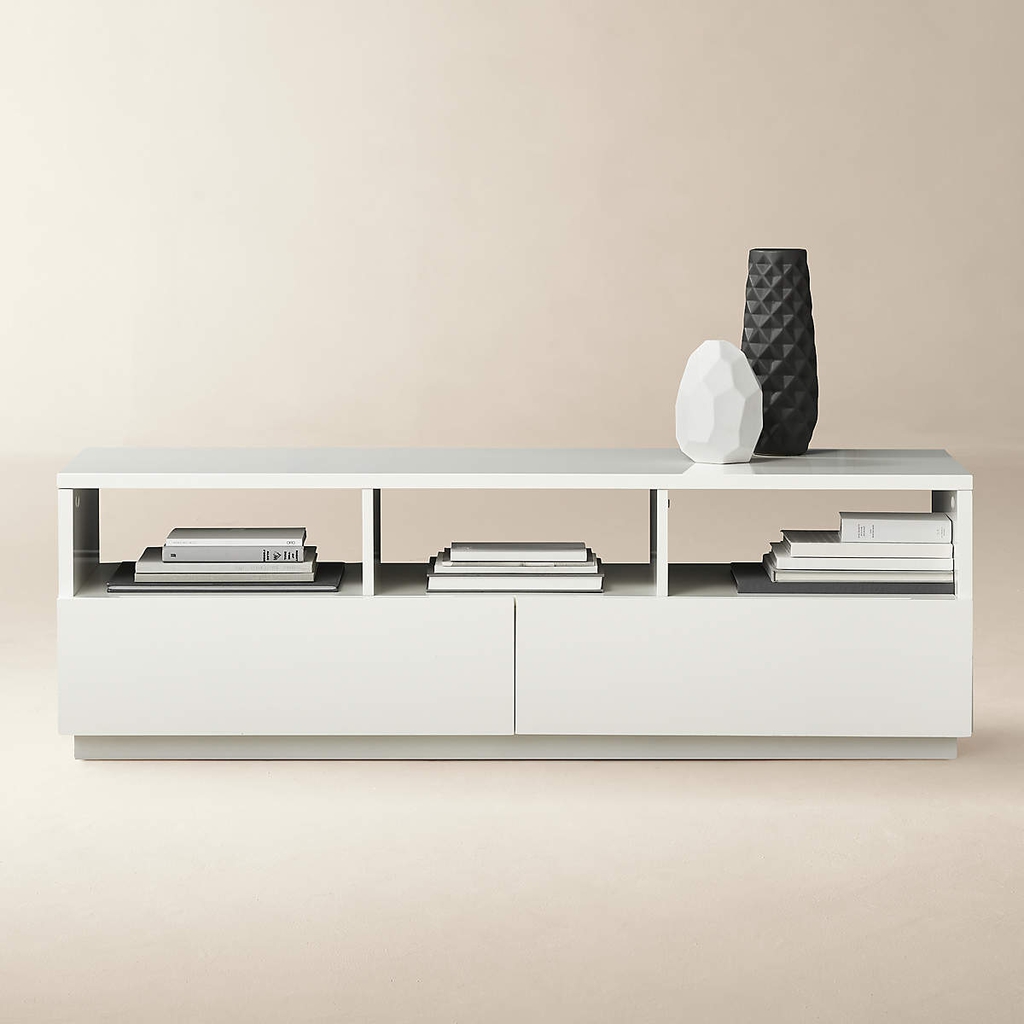 White modern media console with open shelving, closed storage, stacked books, and black-and-white decorative vases.