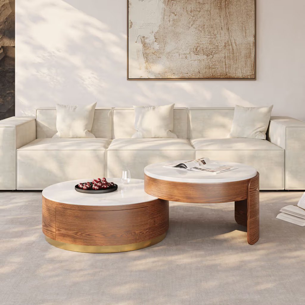 Round nesting coffee tables with white tops and walnut bases in front of a light-colored sofa.