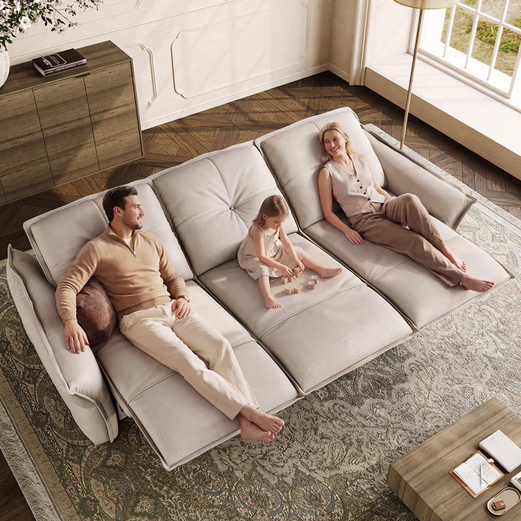 Family relaxing on a large white modular sectional sofa in a bright living room with patterned rug and modern home decor.