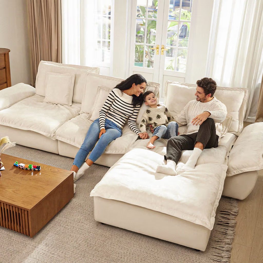 Family relaxing together on a plush cream sectional sofa with chaise in a bright living room.