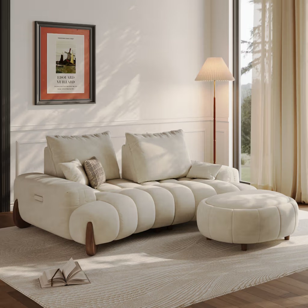 Cream sofa with matching round ottoman in a bright, warm living room.