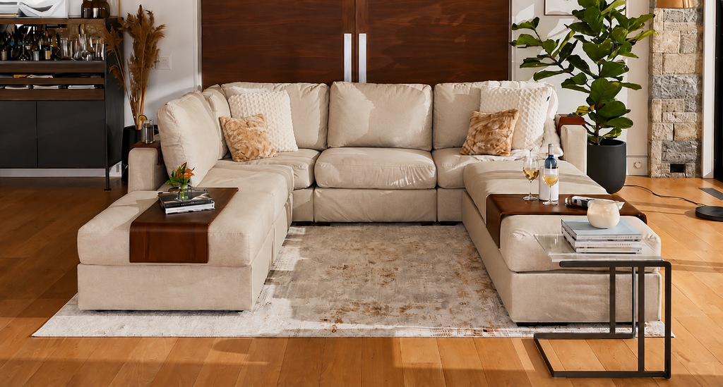 Beige sectional sofa in a modern living room with wood accents and a large potted plant.