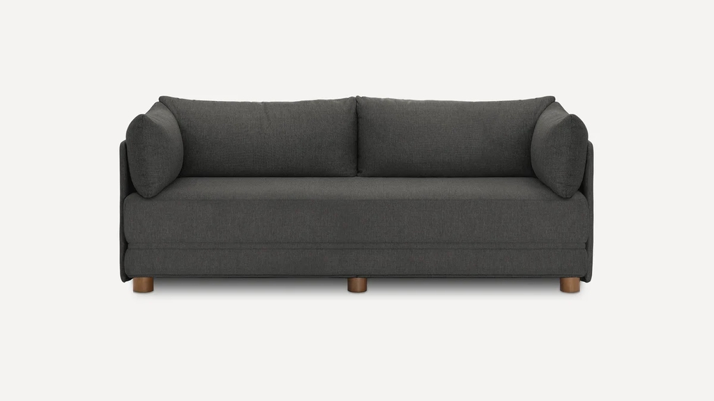 Dark gray sleeper sofa with two back cushions and rounded side pillows on a white background.