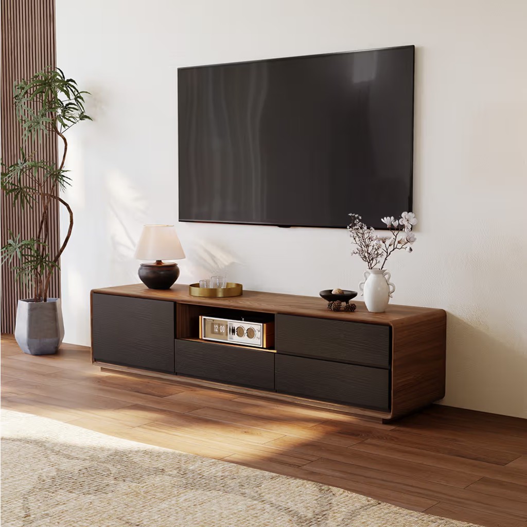 Modern walnut and black media console beneath a wall-mounted TV with open center storage, drawers, and minimalist decor.