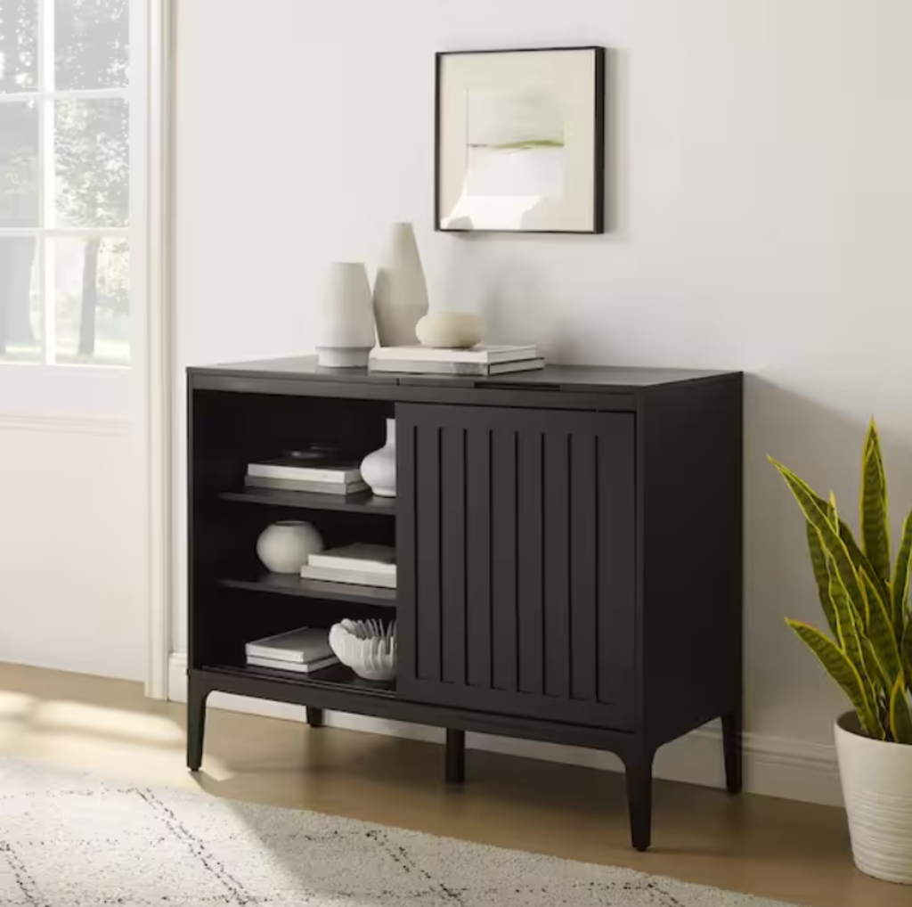 Black slatted-door media console with open shelving in a bright modern living room.
