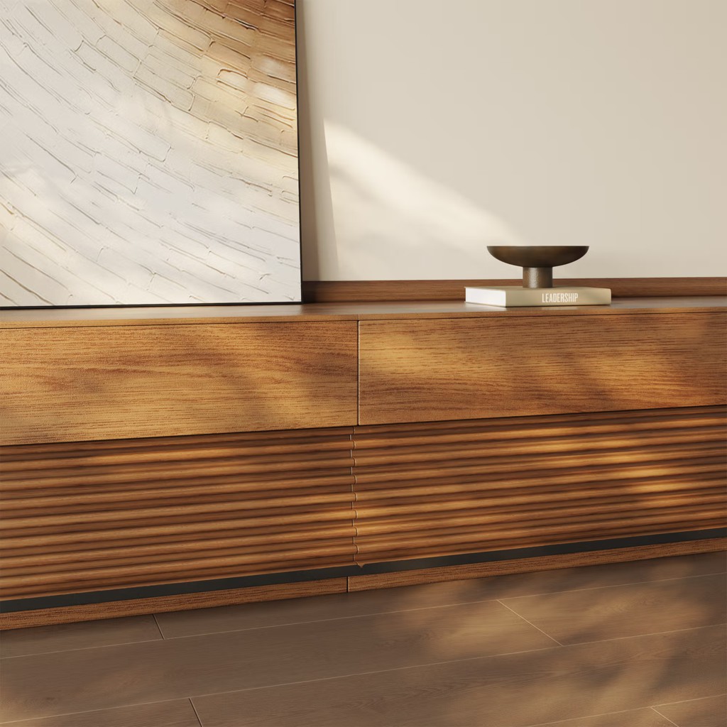 Close-up view of a modern wooden media console with textured slatted doors, warm oak finish, and minimalist decor in a contemporary living room.