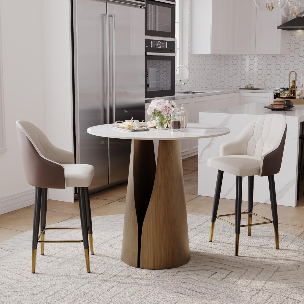 Two upholstered counter stools with black legs and gold footrests beside a round dining table in a modern kitchen.