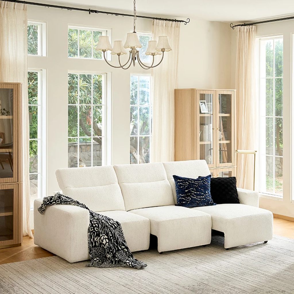 White three-seat power sleeper sofa with independently adjustable sections in a bright living room.