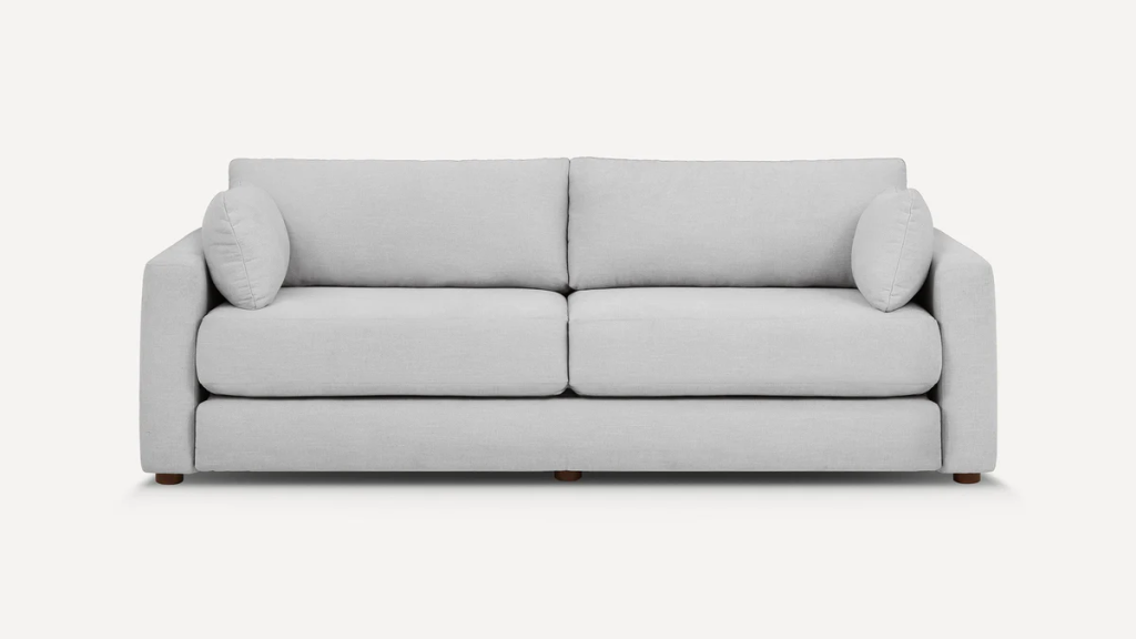 Light gray upholstered sofa with two seat cushions and round bolster pillows on a white background