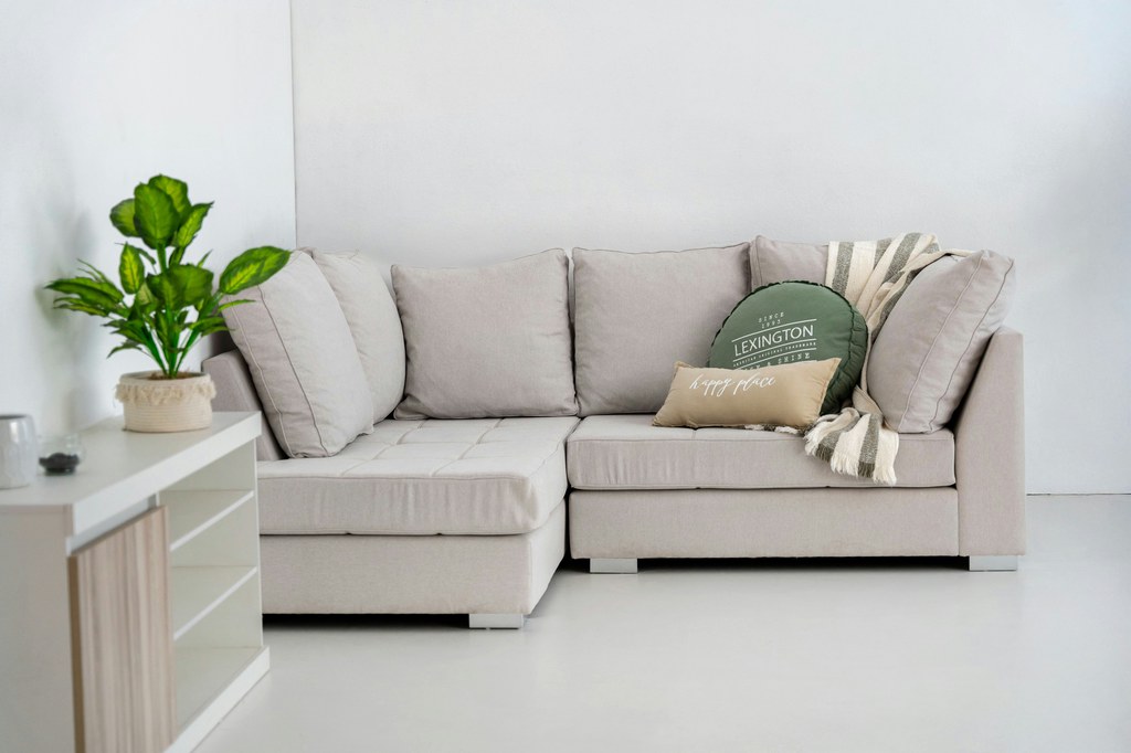 Light beige sectional sofa with plush cushions and chaise in a bright modern living room.