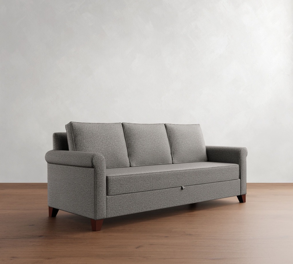 Gray three-seat sleeper sofa with a concealed pull-out section on a wooden floor against a plain white wall.