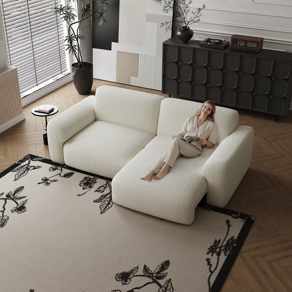 White power sleeper sofa with one section extended for lounging in a modern living room.