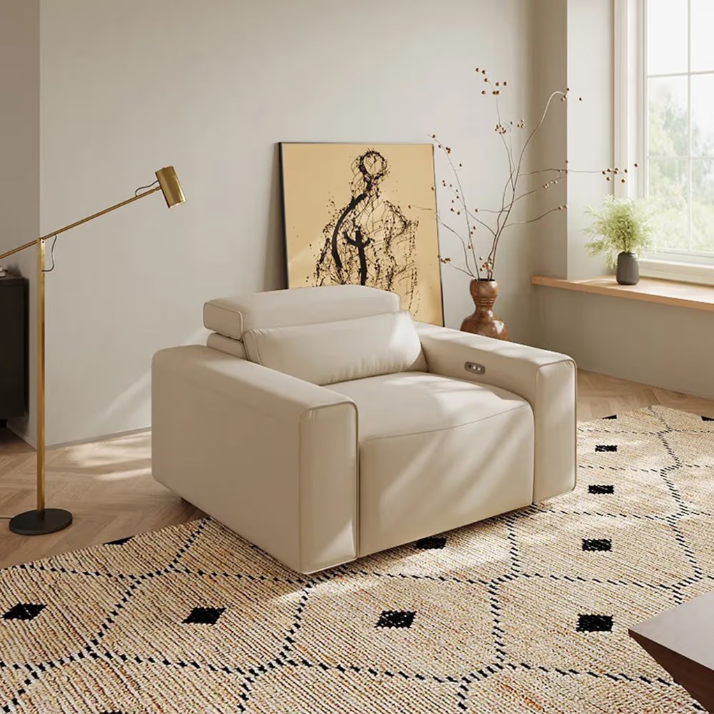 White leather power recliner with adjustable headrest in a bright bedroom reading corner.